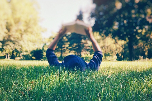 woman reading while laying on grass