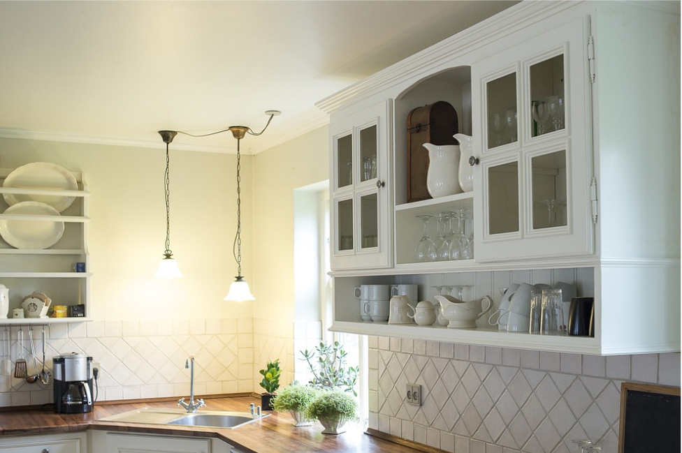 kitchen with white cabinets wood counter succulents pendant lights and sink window