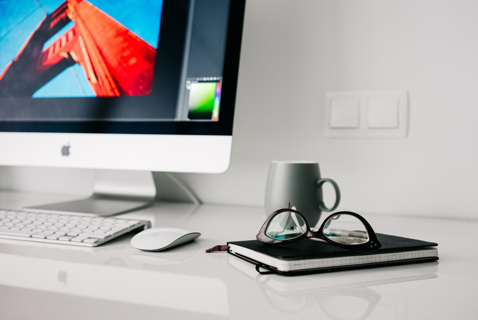 white office desk mac notebook glasses cup
